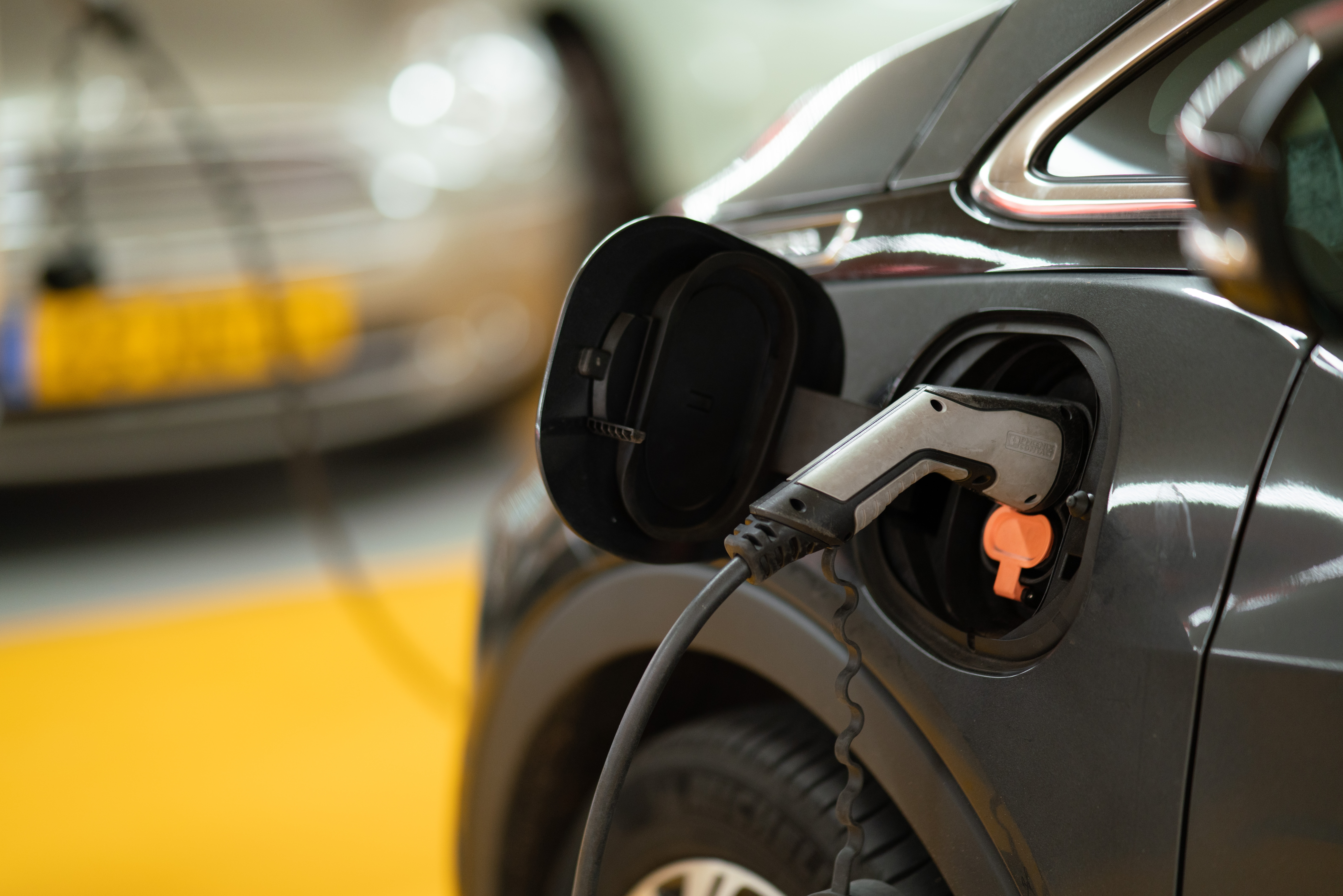 Foto door Michael Fousert op Unsplash. Een elektrische wagen is aan het opladen.