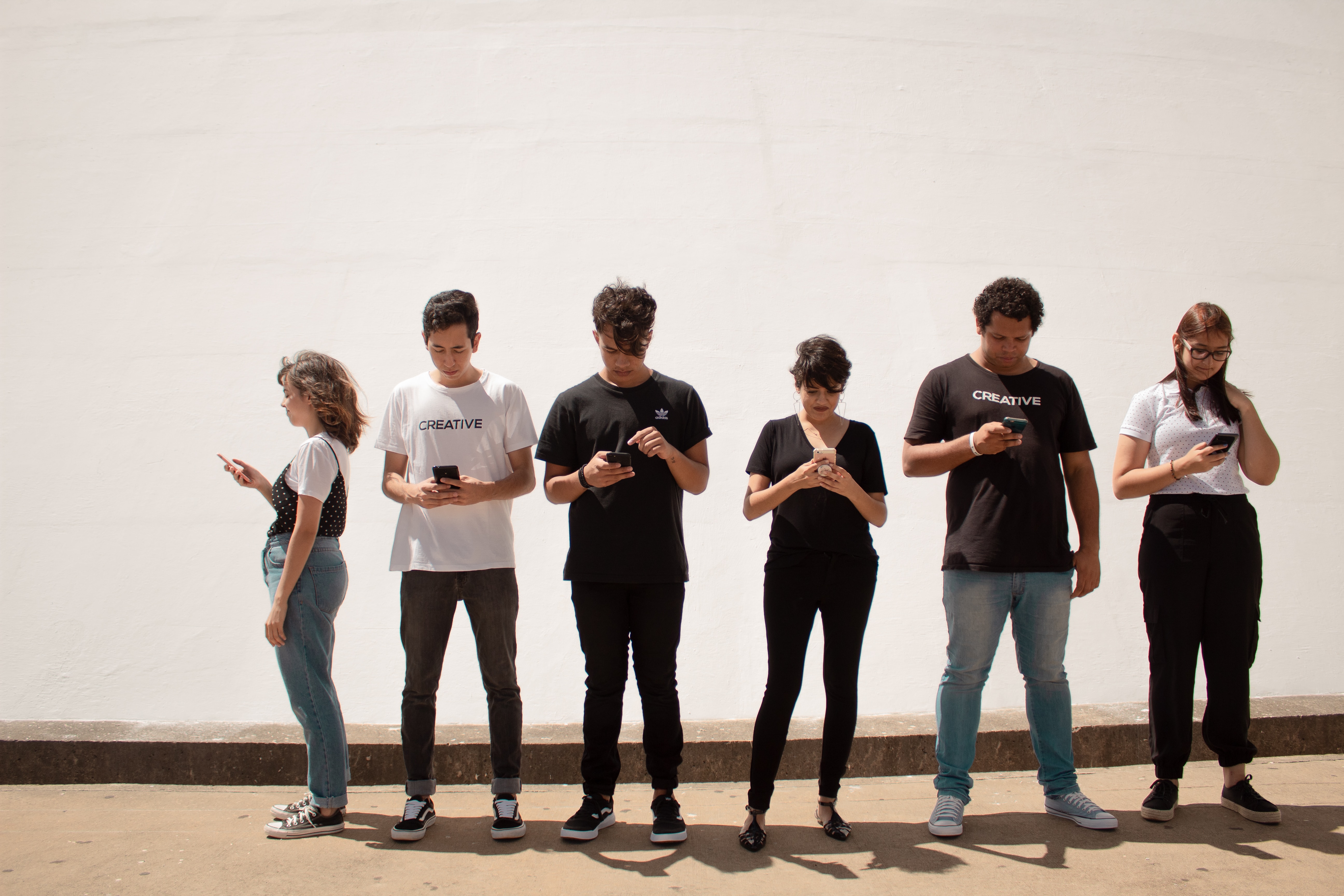 Foto door Creative Christians op Unsplash. Verschillende smartphone gebruikers.