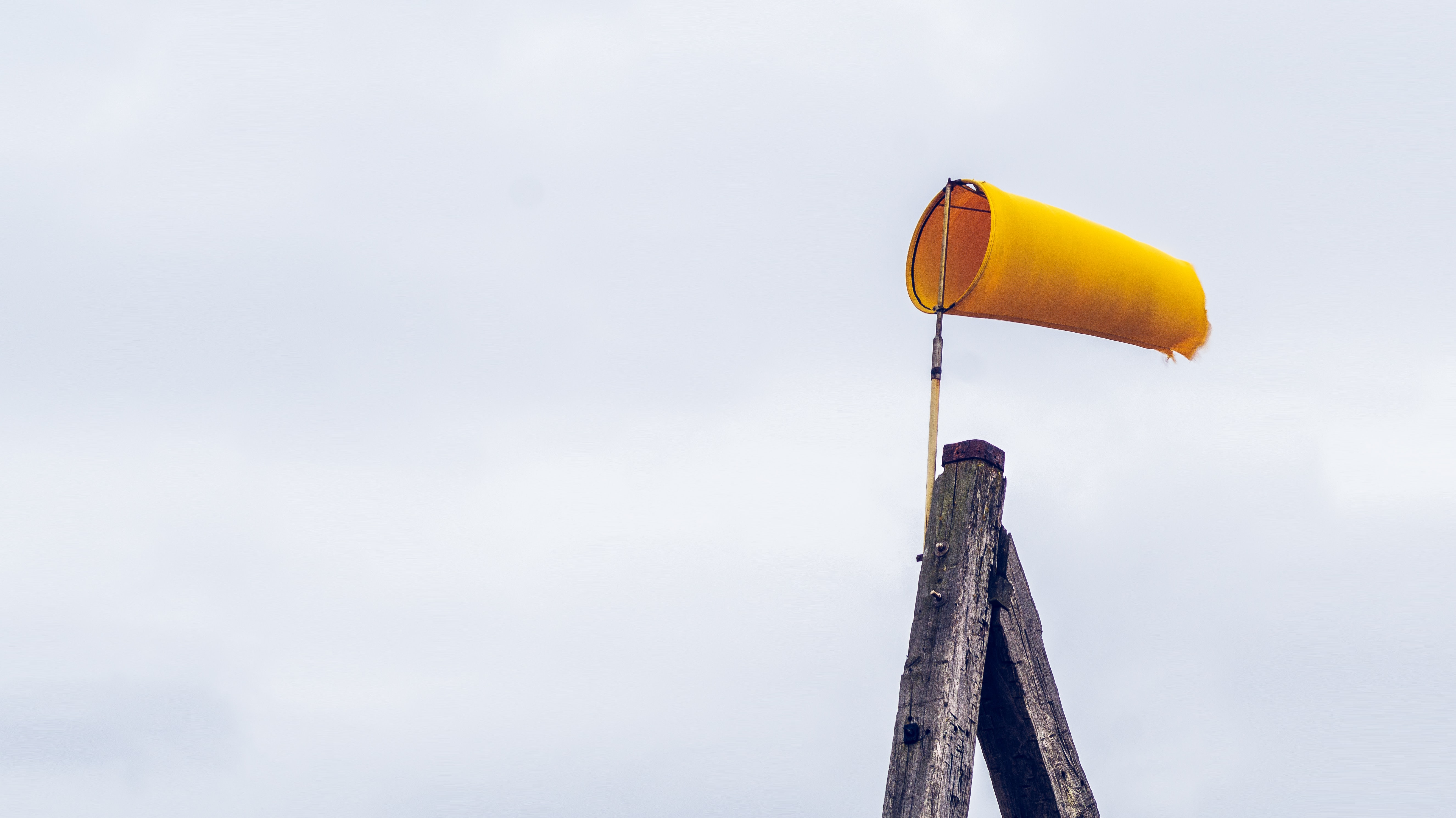 Foto door RoonZ nl op Unsplash. Een windsok op het Nederlands strand.