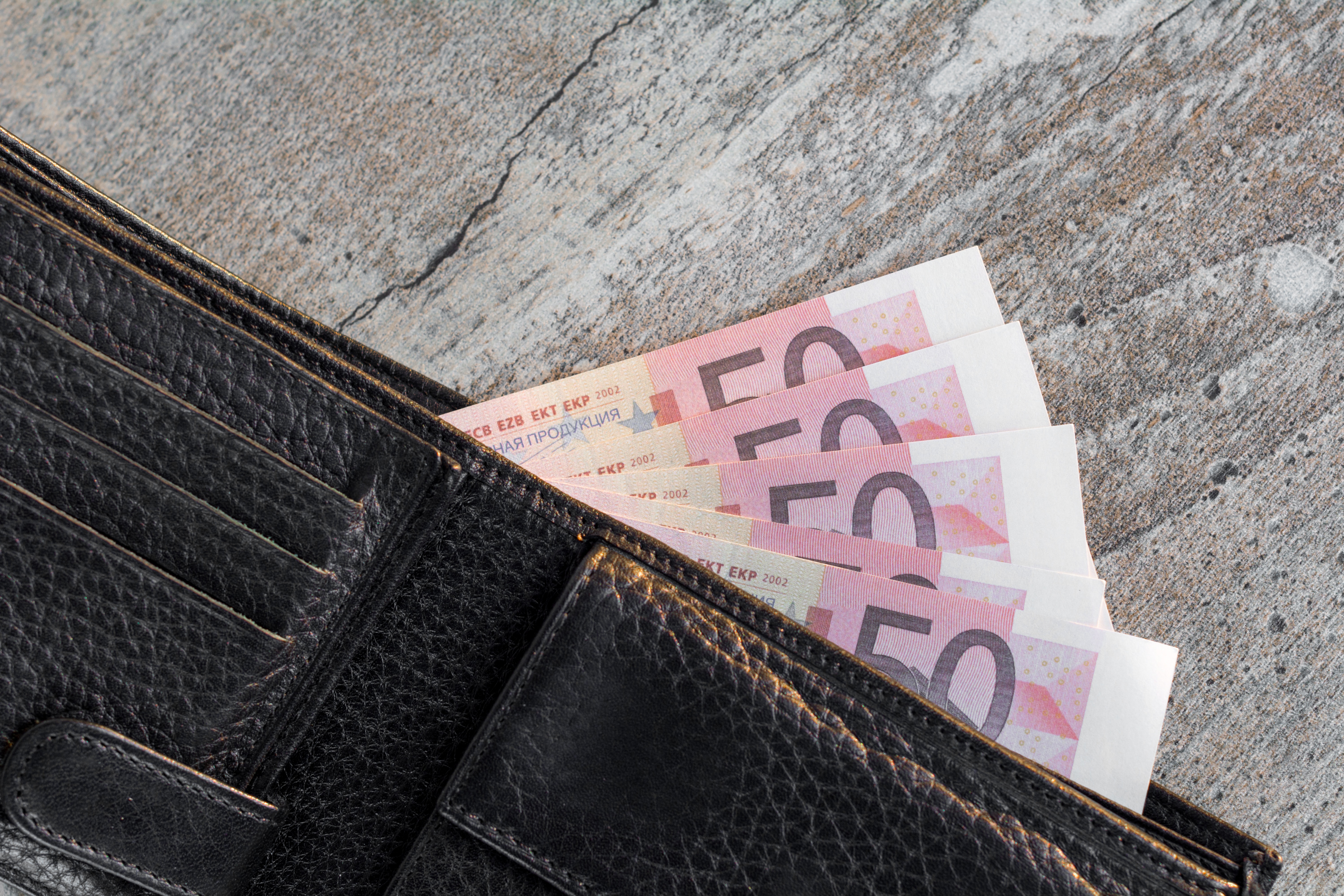 Foto door Bermix Studio op Unsplash. €50 briefjes in een leren portemonnee.